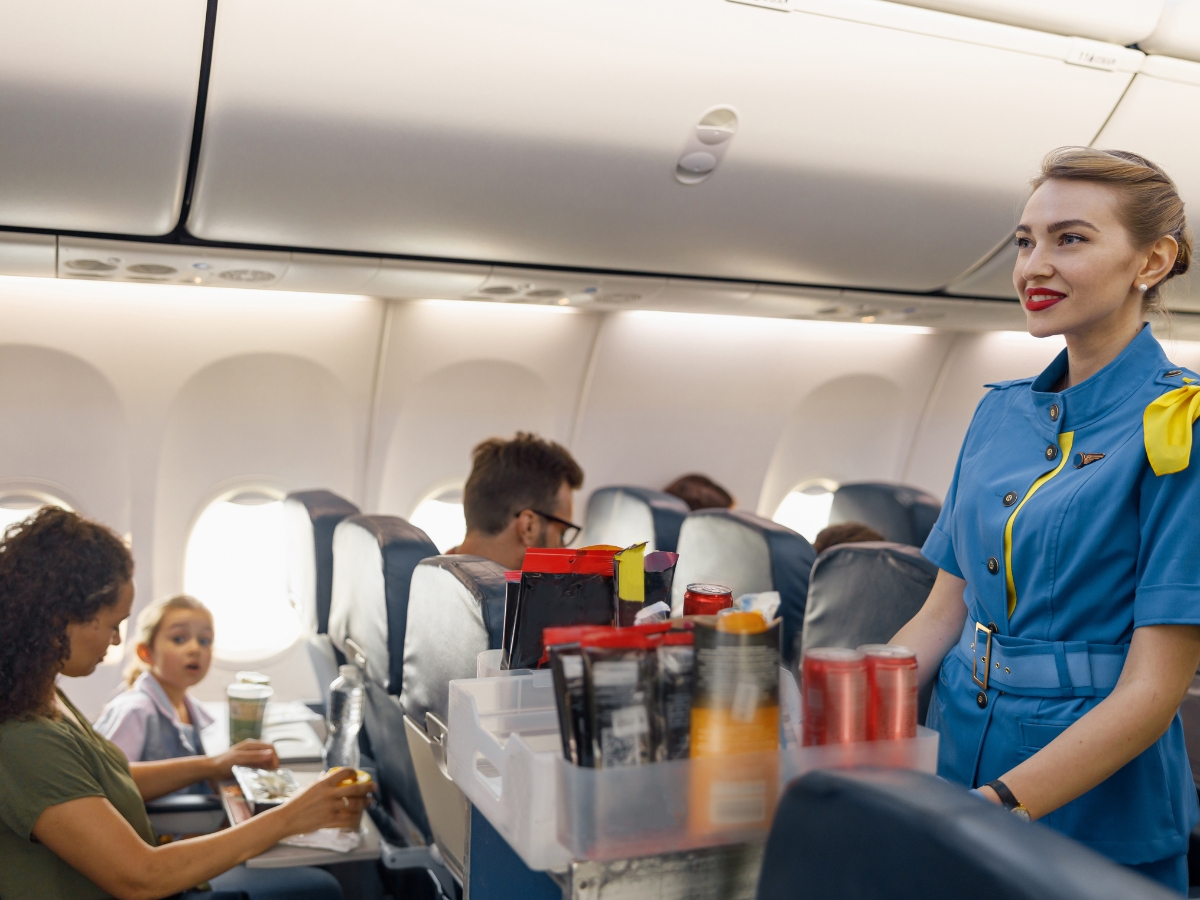 An air hostess serving food to a passenger